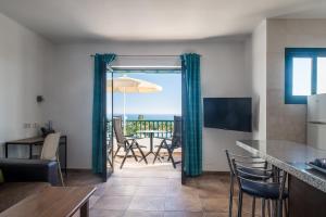 a living room with a kitchen and a table with chairs at Apartamentos Villa Canaima in Puerto del Carmen