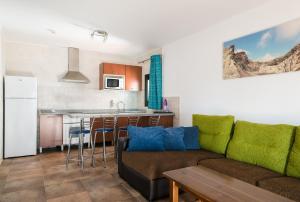a living room with a couch and a kitchen at Apartamentos Villa Canaima in Puerto del Carmen