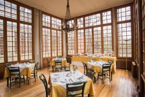 a dining room with tables and chairs and windows at Hotel Casa Real - Viña Santa Rita in Santiago