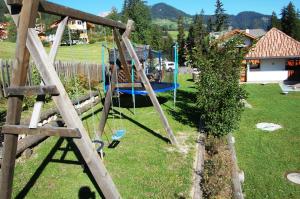a playground in a yard with a swing at Chalet alla Cascata in Badia