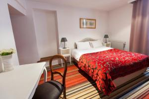 Habitación de hotel con cama con manta roja en Hotel Athanor Centre en Beaune