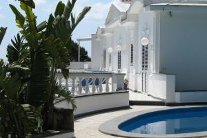 basen przed białym budynkiem w obiekcie Villa Lamaro w mieście Piano di Sorrento