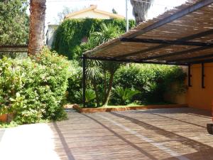 patio z pergolą w ogrodzie w obiekcie Casa Vacanza Appartamenti Al Mare w mieście Capoterra