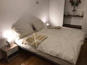 Una cama con sábanas blancas y almohadas en un dormitorio en Casa Cortese en Gallio