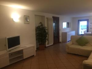 un salon avec une télévision et un canapé dans l'établissement Casa Cortese, à Gallio