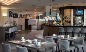 a restaurant with tables and chairs and a bar at Excelsior Hotel Nürnberg Fürth, a member of Radisson Individuals in Fürth