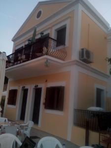 a house with a balcony and a table and chairs at Nikos and Eva Studios in Symi