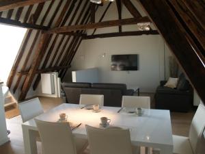 una mesa blanca y sillas en la sala de estar. en Guesthouse Vlamynckpoort, en Brujas