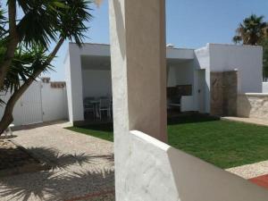 una casa blanca con un patio con una palmera en Casa Albahaca, en El Palmar