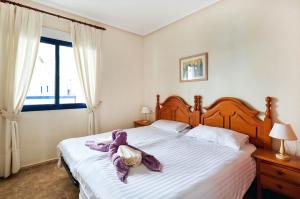Apartment Eva Cabo Roig في كابو رويج: غرفة نوم مع سرير مع بطانية أرجوانية عليه