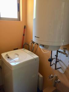 a washing machine in a bathroom next to a toilet at Casa confortable, campo y playa in Buchupureo