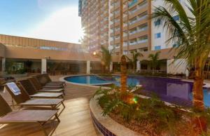 un hotel con sedie a sdraio e piscina di Apto Resort Olimpia a Olímpia