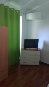 a room with green and white walls and a dresser at Casa "L'Alloria" in Fezzano