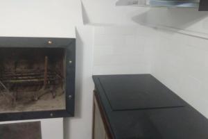 a kitchen with a black cabinet and a tv at Casa "L'Alloria" in Fezzano
