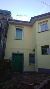 una grande casa bianca con una porta verde di Casa "L'Alloria" a Fezzano