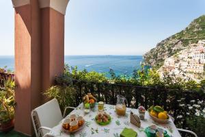 stół z jedzeniem i widokiem na ocean w obiekcie Casa Annalu w mieście Positano