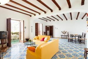 un soggiorno con divano giallo e TV di Casa Annalu a Positano