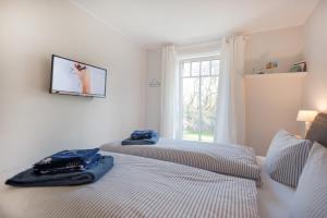 two twin beds in a room with a window at Dünenstern in Wangerooge