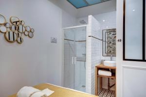 a white bathroom with a shower and a sink at LE COCOON 29 by Cocoonr in Bordeaux