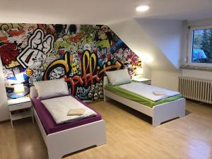 a room with two beds and a wall covered in graffiti at Wondervolles zuhause auf Zeit in Moers