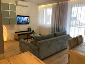 a living room with a couch and a flat screen tv at Apartament Turkus in Kościerzyna