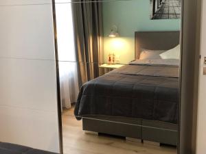 een slaapkamer met een bed en een spiegel bij Apartament Turkus in Kościerzyna