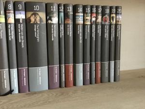a row of books sitting on a shelf at Moka & Vanille in Heusden - Zolder