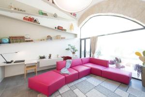 パレルモにあるGattopardo Apartments By LAGO Designのリビングルーム(ピンクのソファ、テーブル付)