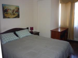 Un dormitorio con una cama grande y una ventana en Rodeo Departamentos Amoblados en Rancagua