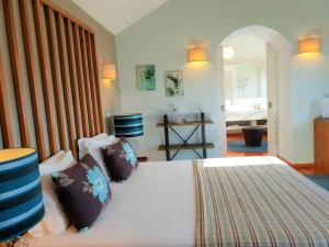 a bedroom with a large white bed with pillows at Quinta da Palmeira - Country House Retreat & Spa in Cerdeira