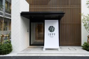 HOTEL 1899 TOKYO في طوكيو: باب مع علامة أمام المبنى