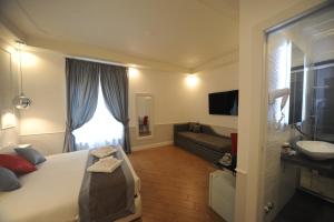 a bedroom with a bed and a sink and a couch at My Suites Piazza di Spagna in Rome