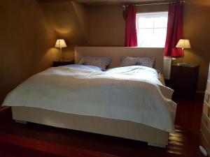 Schlafzimmer mit einem großen weißen Bett und einem Fenster in der Unterkunft Haus Nr. 9 in Ruppichteroth