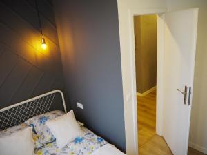 ワルシャワにあるApartment Sigismondo Zoliborzの小さなベッドルーム(ベッド1台付)、廊下が備わります。
