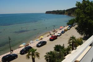 eine Gruppe von Autos, die am Strand neben dem Wasser geparkt werden in der Unterkunft Hotel Achillion in Makrýgialos