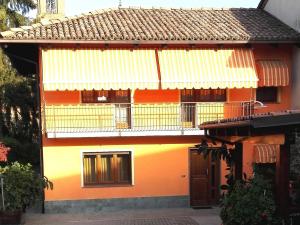 Dieses orangefarbene und gelbe Haus verfügt über einen Balkon. in der Unterkunft Casa Sammo in Piobesi dʼAlba