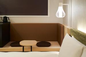 a bed with a table and a stool in a room at HOTEL 1899 TOKYO in Tokyo