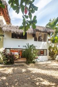 a house with a thatched roof and a courtyard at Casa Silvana - Villas del Palmar in Sayulita