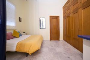1 dormitorio con 1 cama con manta amarilla en AlohaMundi Valvanera, en Sevilla