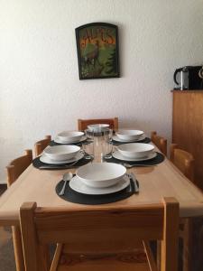 einem Holztisch mit Tellern und Servietten darauf in der Unterkunft Appartement Pied de pistes et Coeur de station in La Salle Les Alpes