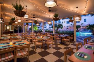 Un restaurante con mesas, sillas y luces. en The Plymouth South Beach, en Miami Beach