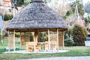 a wooden gazebo with a grass roof at Agroturystyka uDuraja in Kiczora
