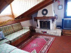 a living room with a couch and a fireplace at Appartamento Piancavallo in Piancavallo