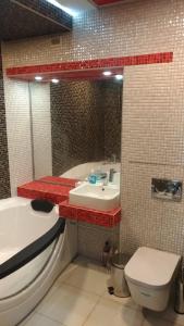 La salle de bains est pourvue d'une baignoire, d'un lavabo et de toilettes. dans l'établissement Falcon-X apartment, à Mykolaïv