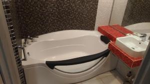 een badkamer met een wit bad en een wastafel bij Falcon-X apartment in Nikolayev