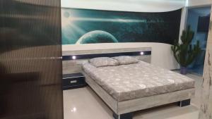 a bedroom with a bed and a painting on the wall at Falcon-X apartment in Mykolaiv