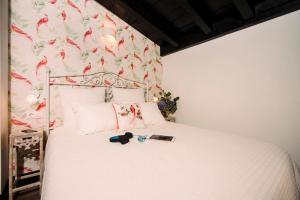 1 dormitorio con cama blanca y papel pintado con motivos florales en Casa Calma Rural, en Taramundi