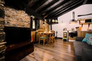 cocina y sala de estar con mesa y sofá en Casa Calma Rural, en Taramundi