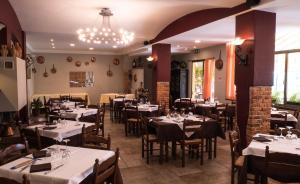 a restaurant with tables and chairs and a chandelier at Albergo Ristorante Monterosa in Ameno