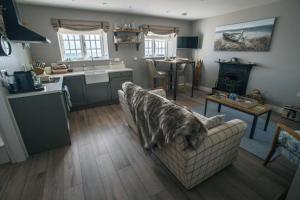 a living room with a couch and a kitchen at Rockport Lodge in Cushendun